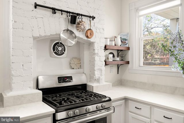 a kitchen with a stove and a clock on the wall