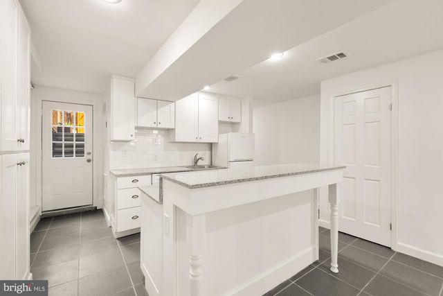 a kitchen with white cabinets and white appliances