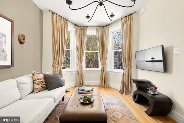 a living room with furniture a large window and a chandelier