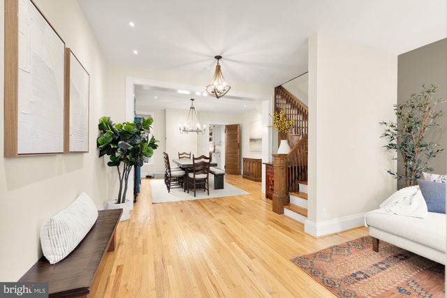 a living room with furniture and potted plants