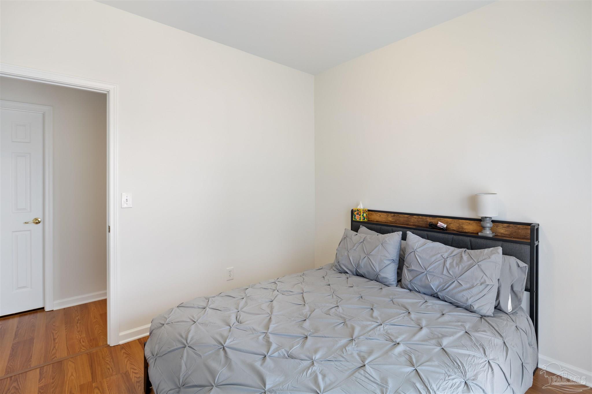 6887 Crimson Ridge Street Gulf Shores, AL 36542 - Photo 20 of 37 a bedroom with a bed and wooden floor