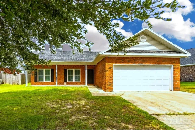 a front view of a house with a garden and trees