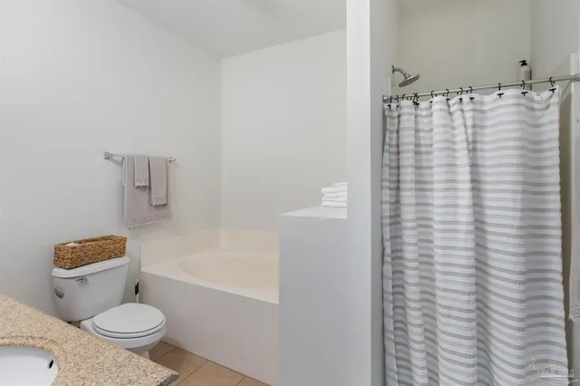a bathroom with a granite countertop sink toilet a mirror and shower