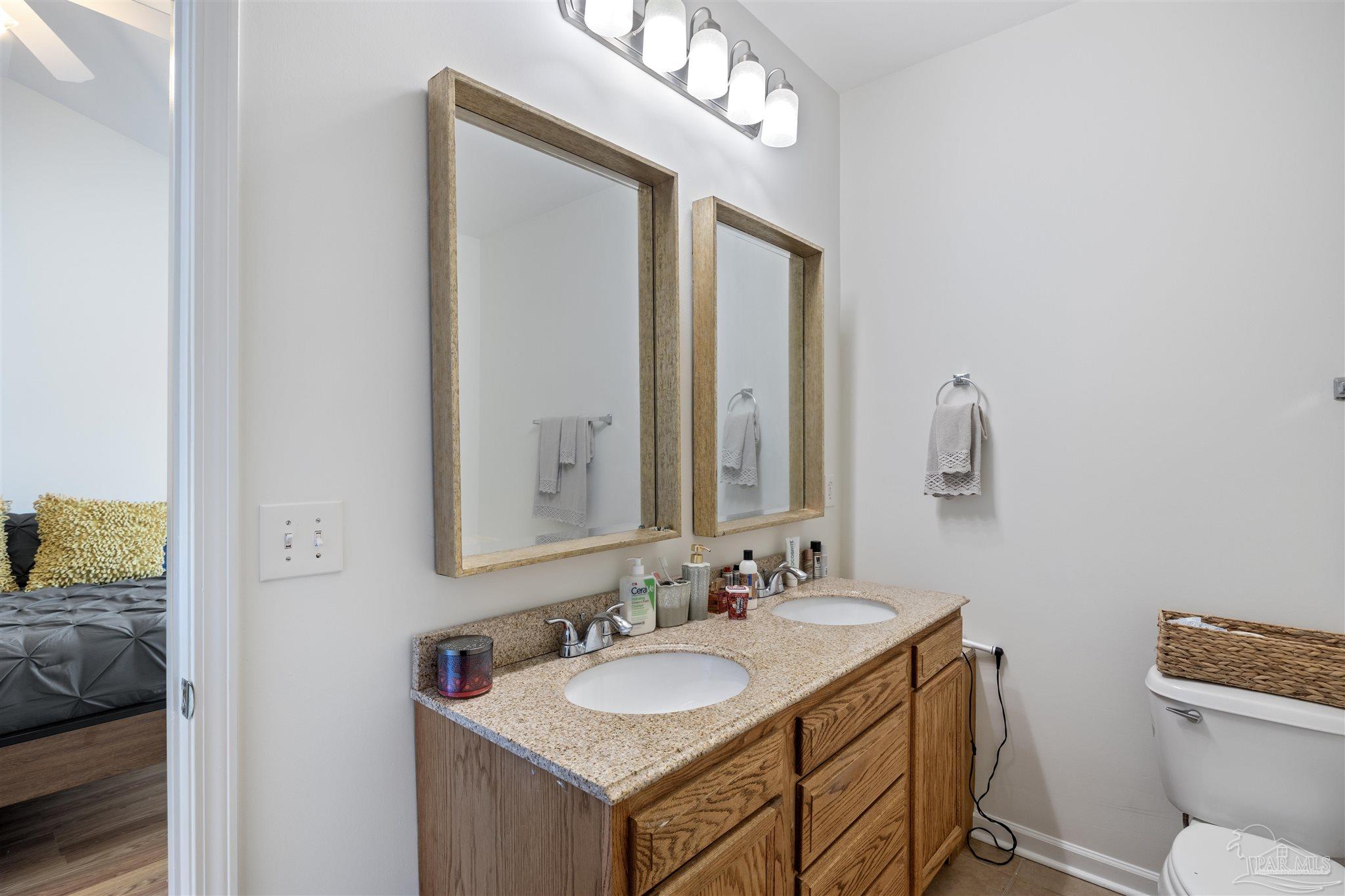 6887 Crimson Ridge Street Gulf Shores, AL 36542 - Photo 27 of 37 a bathroom with a sink vanity granite and a mirror