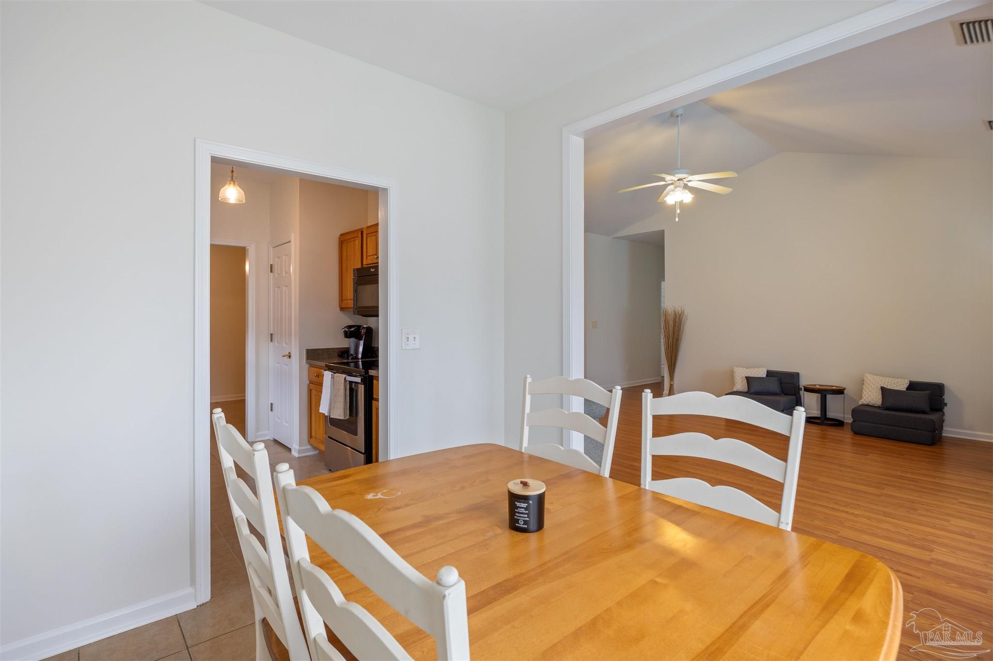 6887 Crimson Ridge Street Gulf Shores, AL 36542 - Photo 9 of 37 a dining room with furniture and wooden floor