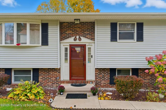 a view of a house with potted plants and a bench