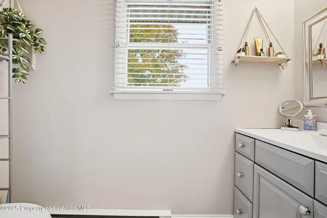 a bathroom with a sink a vanity and a window