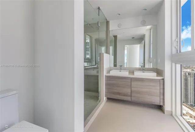 a bathroom with a double vanity sink mirror and toilet