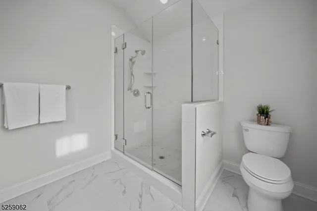 a bathroom with a granite countertop toilet a sink and shower