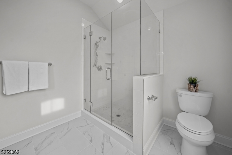 147 Center Avenue, Unit 17 Old Tappan, NJ 07675 - Photo 29 of 48 a bathroom with a granite countertop toilet a sink and shower