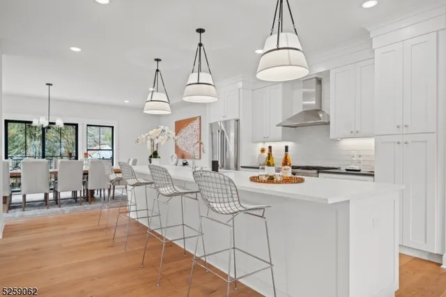 a kitchen with stainless steel appliances a stove a sink a center island and cabinets