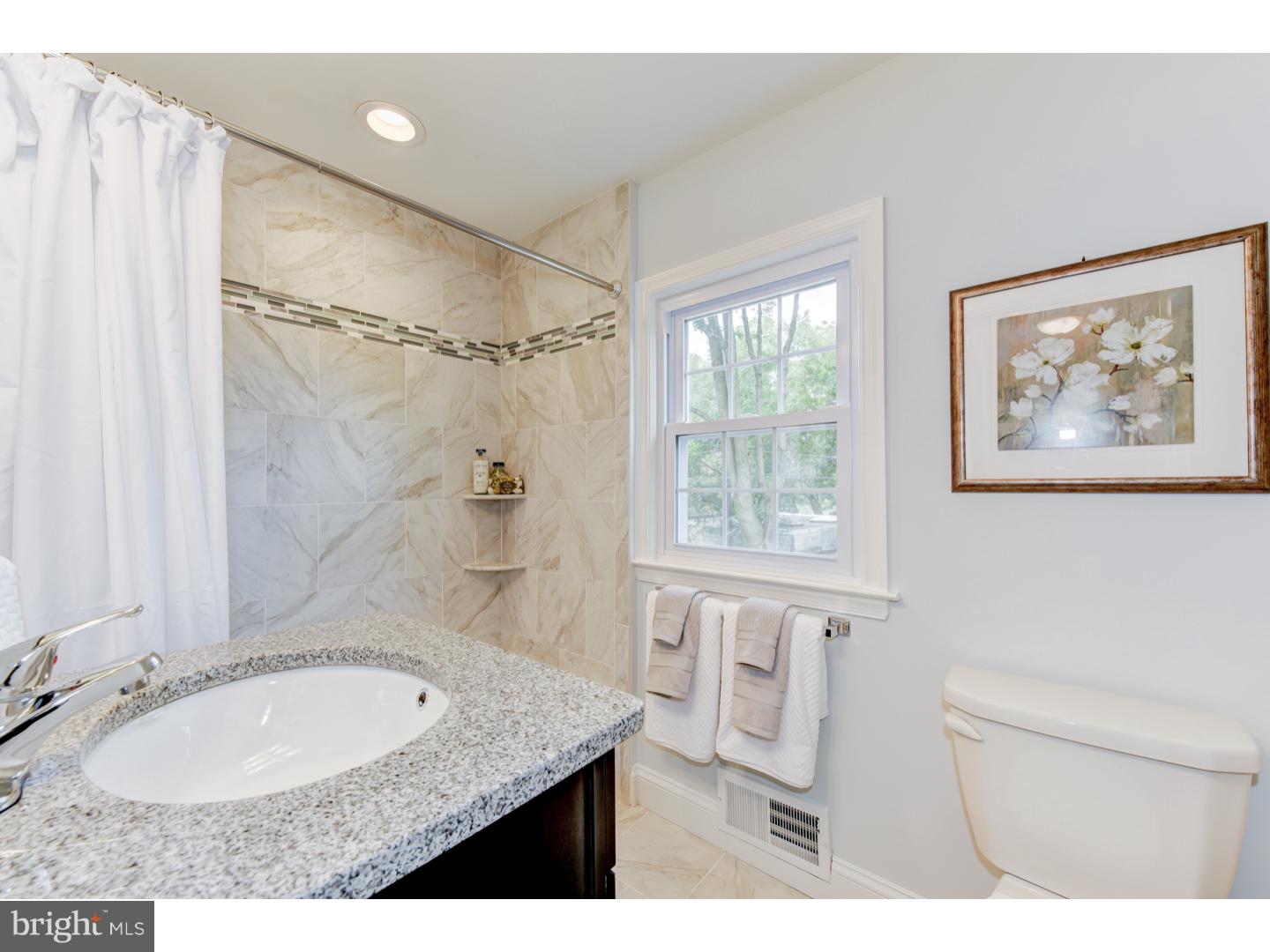 2224 Avon Road Ardmore, PA 19003 - Photo 19 of 23 a bathroom with a granite countertop sink a mirror a bathtub and shower