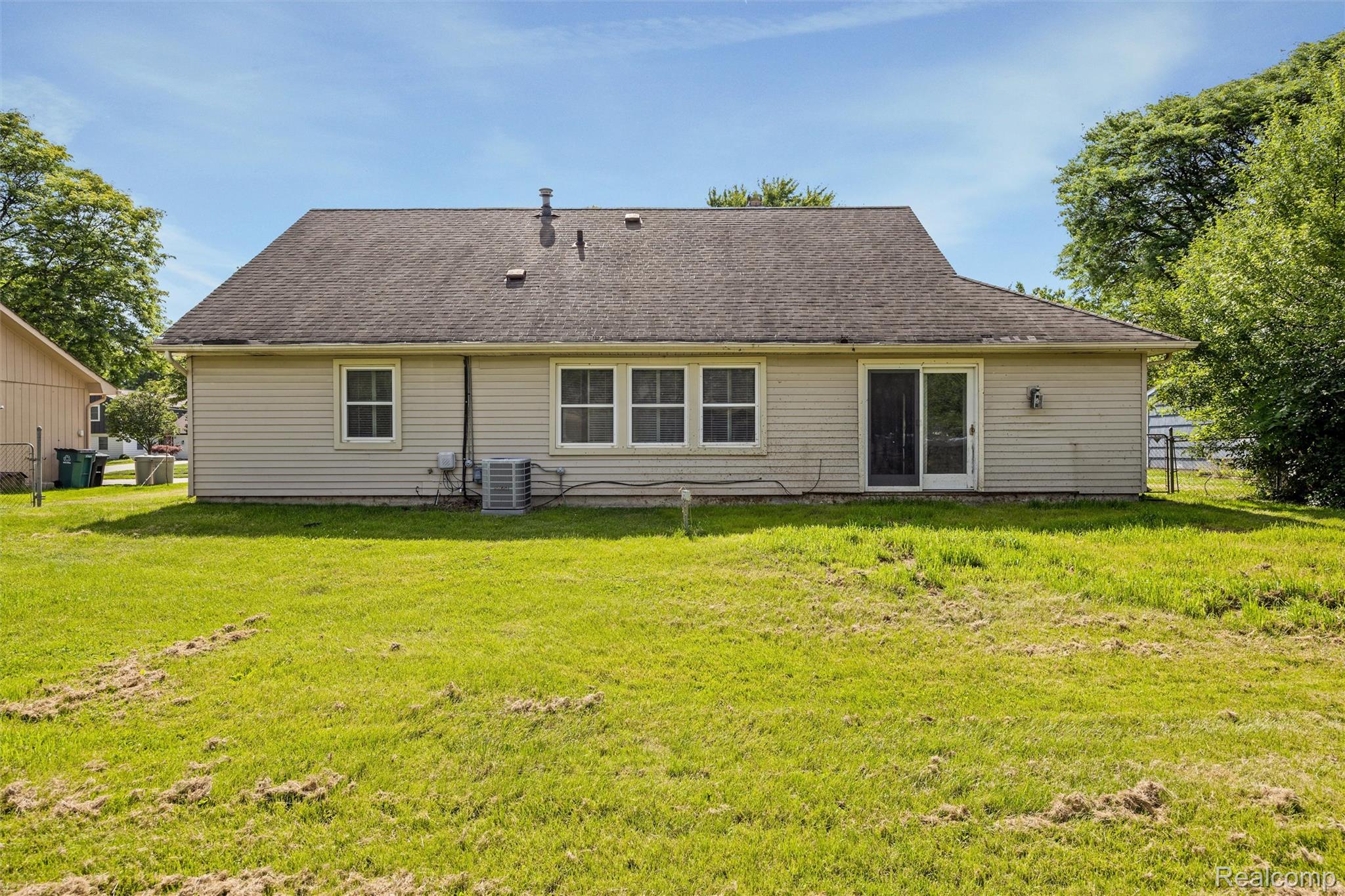 4942 Butler Drive Troy, MI 48085 - Photo 31 of 33 Rear exterior of a single-story home featuring light-colored siding and a dark shingled roof