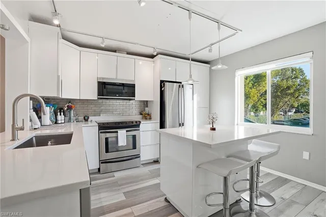a kitchen with kitchen island a stove a sink and a refrigerator