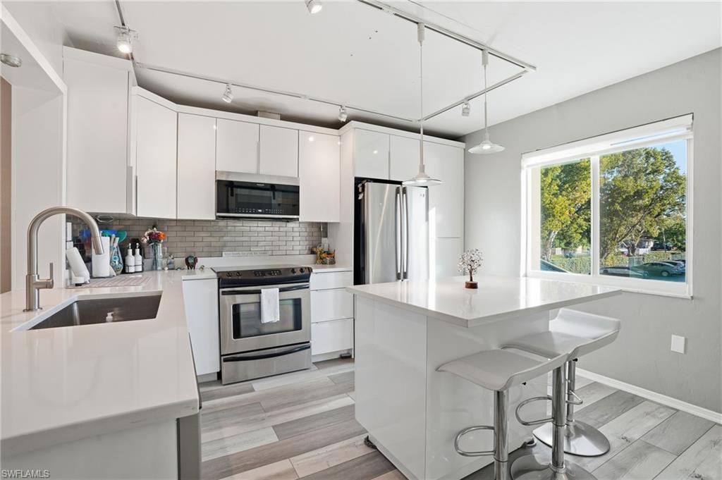 a kitchen with kitchen island a stove a sink and a refrigerator