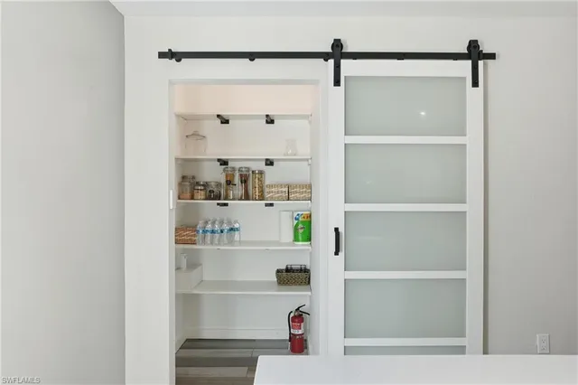 a room with kitchen island and stainless steel appliances