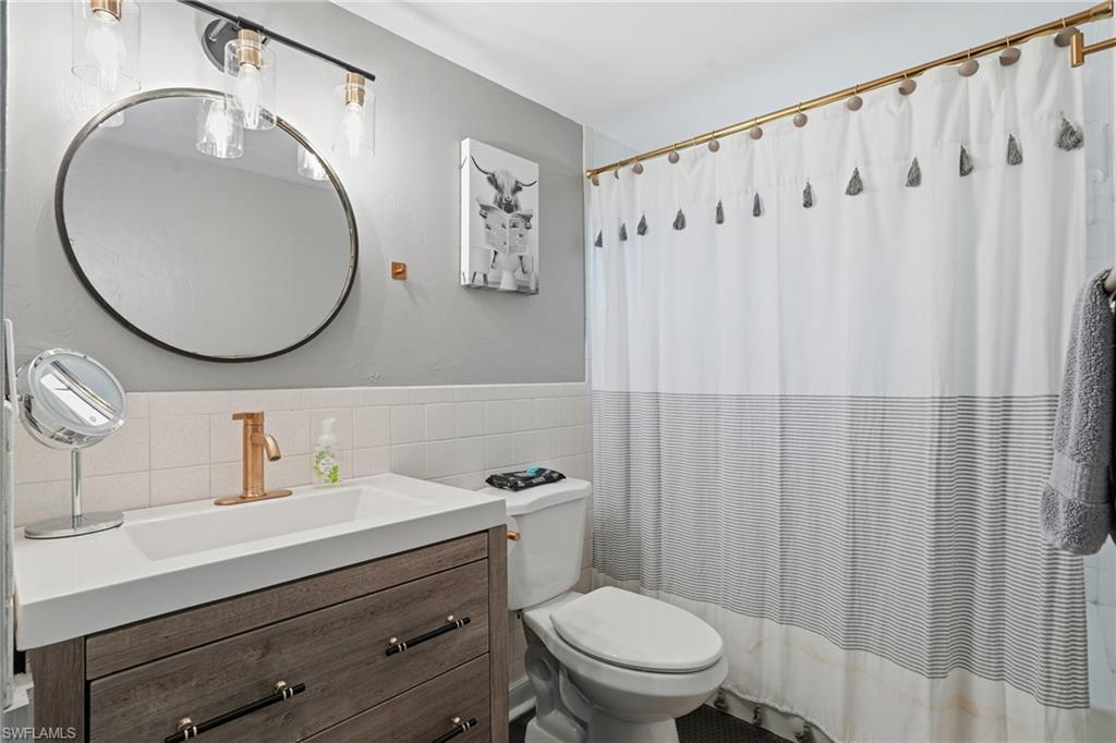 2828 Jackson Street, Unit H6 Fort Myers, FL 33901 - Photo 21 of 27 a bathroom with a toilet a sink and a mirror