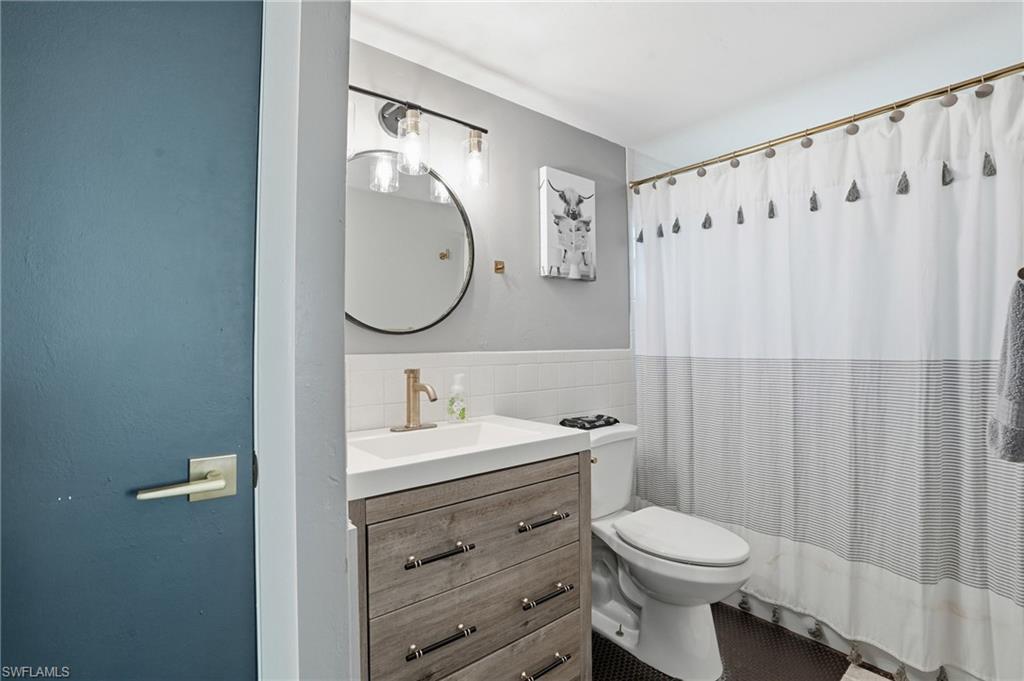 2828 Jackson Street, Unit H6 Fort Myers, FL 33901 - Photo 22 of 27 a bathroom with a toilet sink vanity and mirror