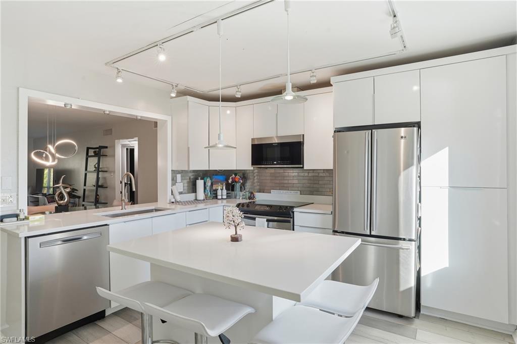 2828 Jackson Street, Unit H6 Fort Myers, FL 33901 - Photo 3 of 27 a kitchen with white cabinets and stainless steel appliances