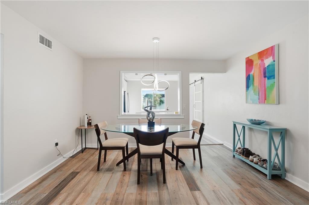 2828 Jackson Street, Unit H6 Fort Myers, FL 33901 - Photo 8 of 27 a view of a dining room with furniture and wooden floor