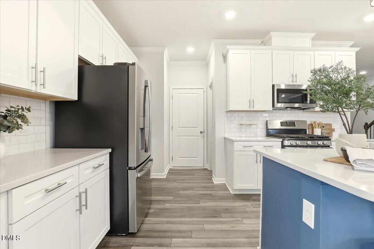 5052 Tura Street Raleigh, NC 27610 - Photo 9 of 47 a kitchen with a refrigerator and a stove top oven