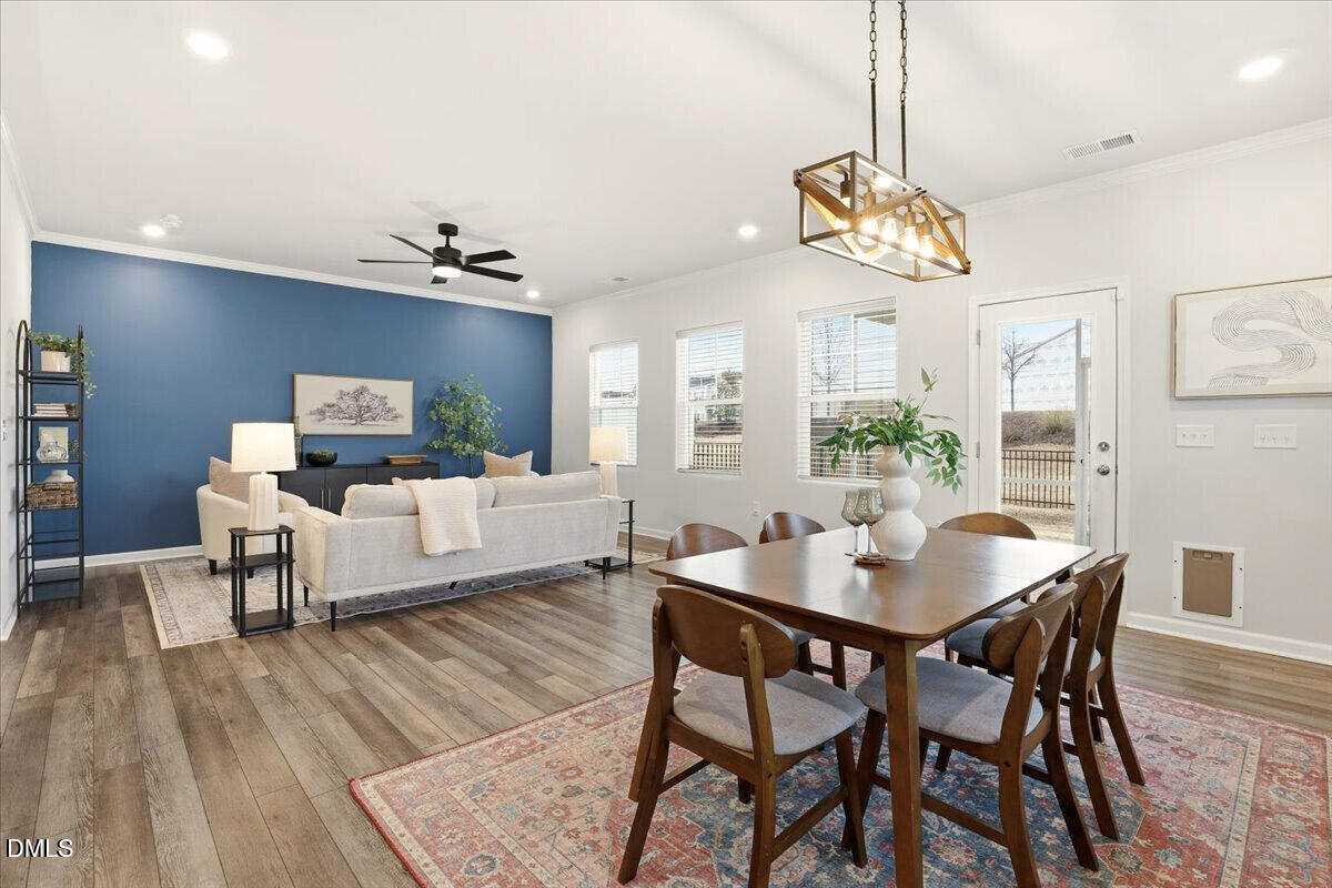 5052 Tura Street Raleigh, NC 27610 - Photo 11 of 47 a view of a dining room with furniture a chandelier and wooden floor