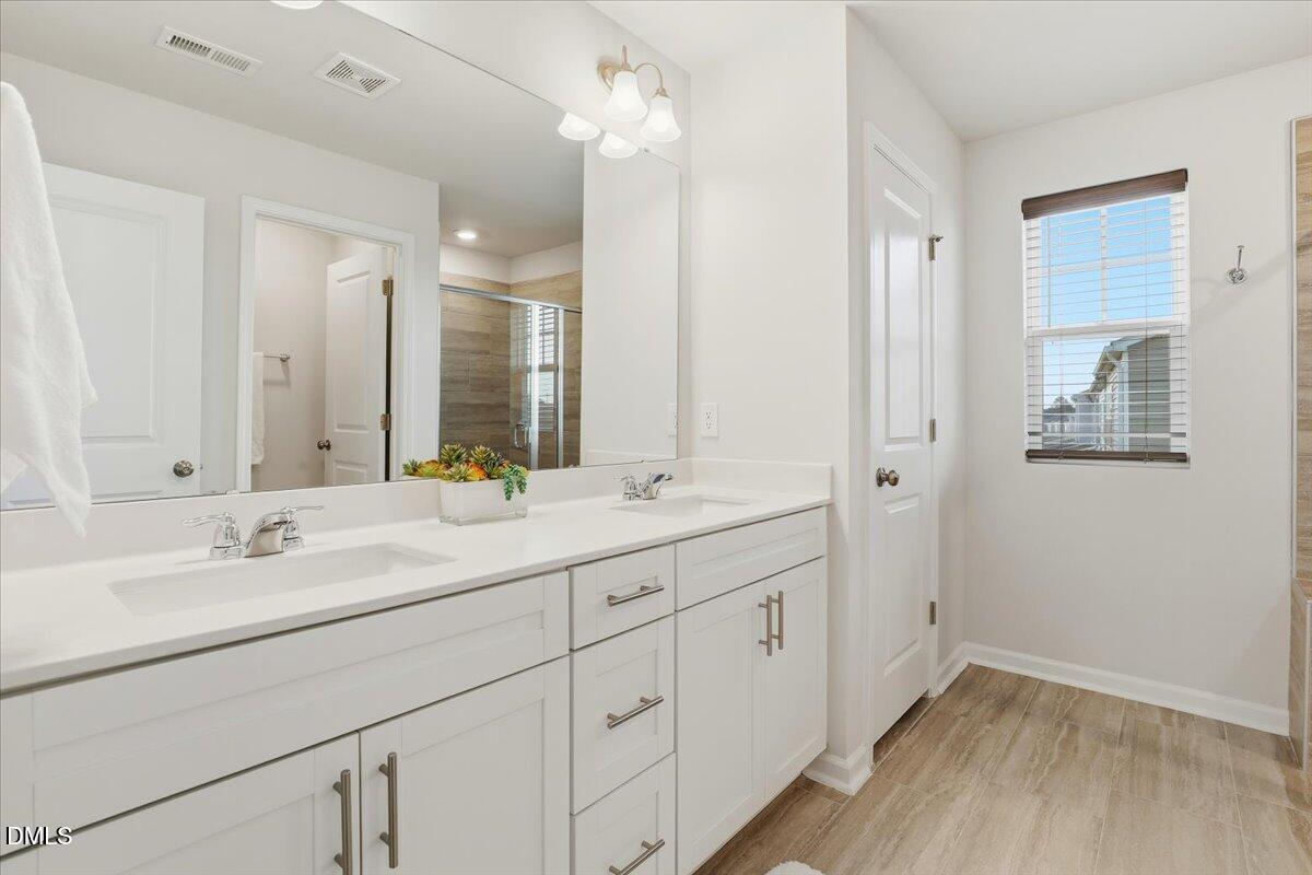 5052 Tura Street Raleigh, NC 27610 - Photo 19 of 47 a bathroom with a double vanity sink and a mirror