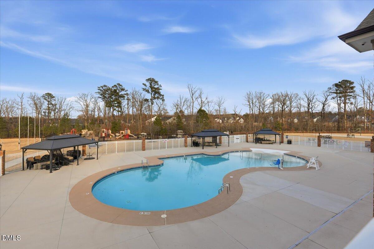 5052 Tura Street Raleigh, NC 27610 - Photo 29 of 47 a view of a swimming pool with outdoor seating and a shower