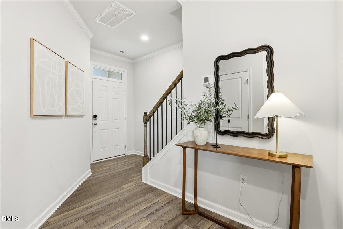 5052 Tura Street Raleigh, NC 27610 - Photo 3 of 47 a view of staircase with wooden floor and small potted plant