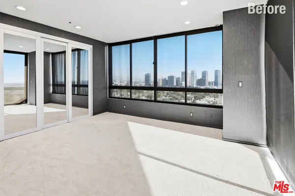 a large bedroom with a large window and bed