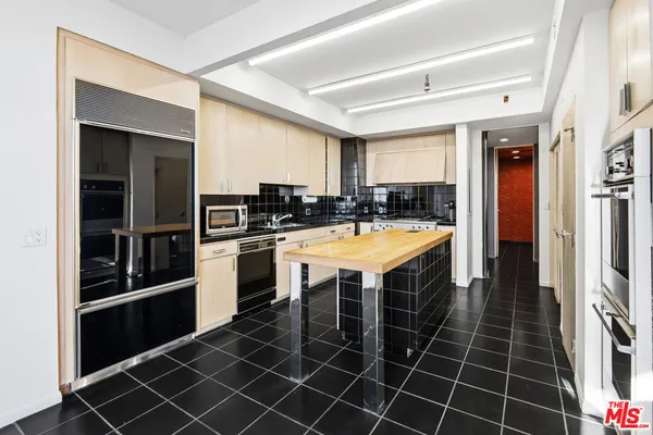 a kitchen with stainless steel appliances a sink and cabinets