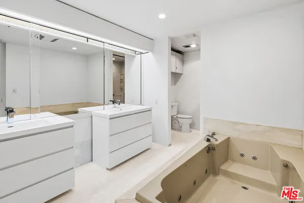 a bathroom with a tub sink mirror and vanity