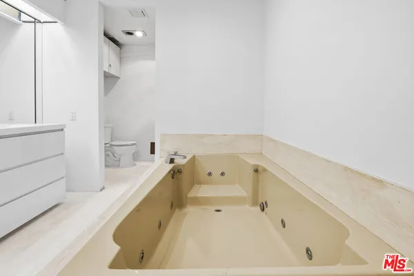 a bathroom with a tub sink and mirror