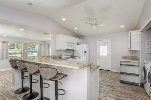 a large kitchen with kitchen island a large counter space and stainless steel appliances