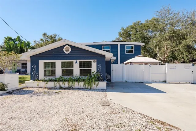 a front view of a house with a yard and potted plants