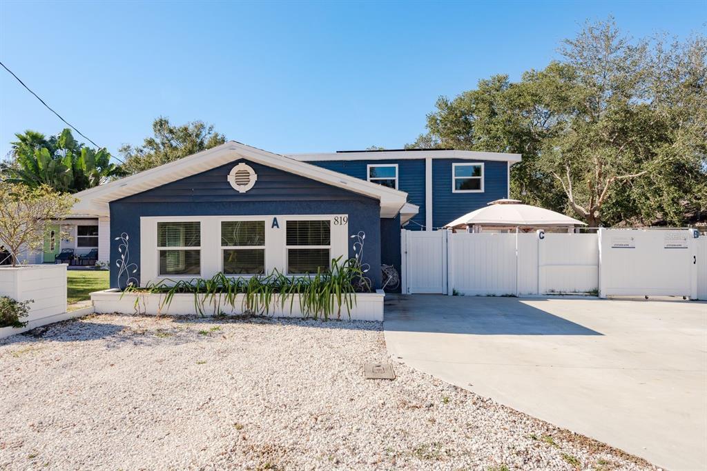 819 10th Street Southwest, Unit A Largo, FL 33770 - Photo 2 of 29 a front view of a house with a yard and potted plants