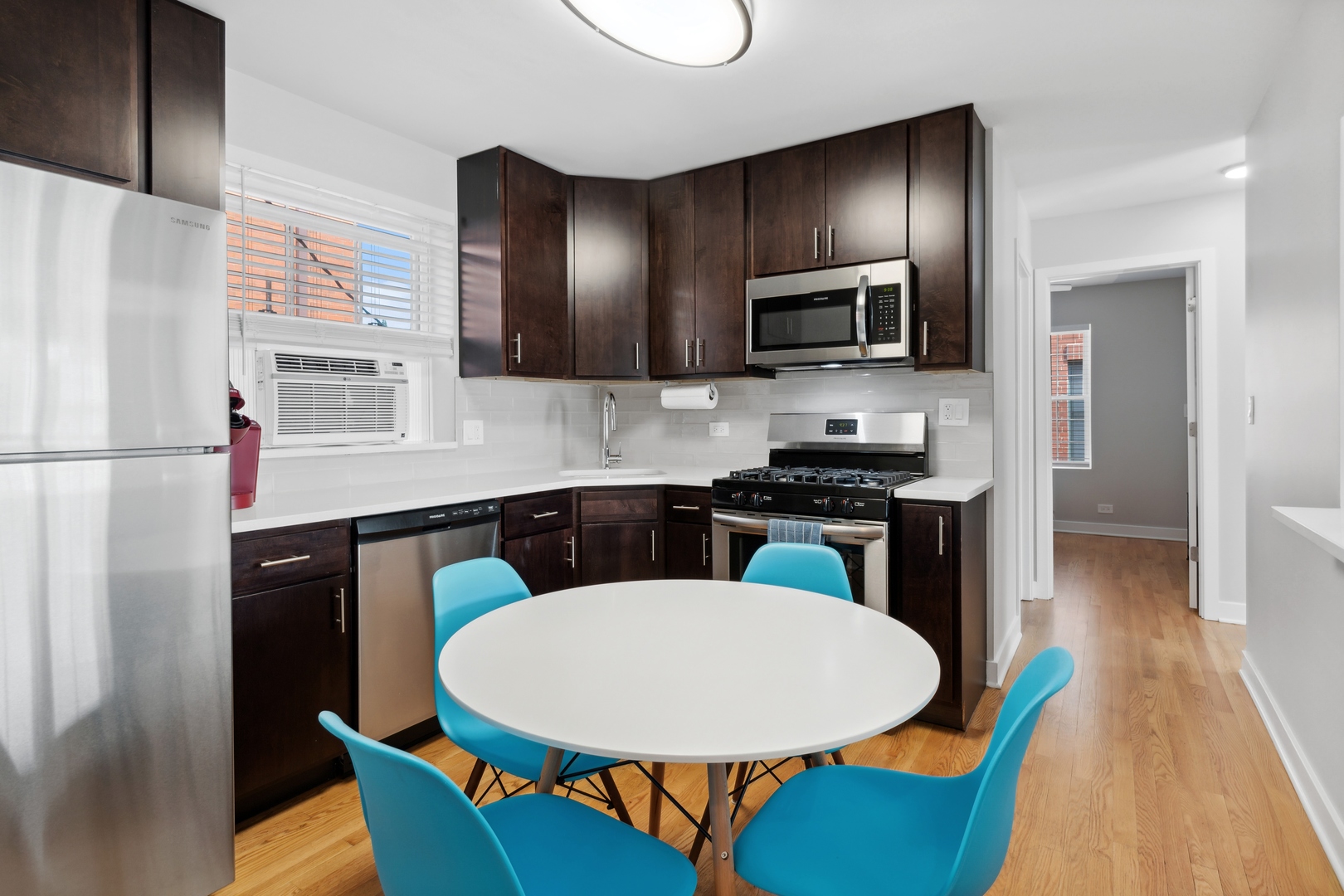 136 Ridge Avenue, Unit 2 Evanston, IL 60202 - Photo 5 of 12 a kitchen with stainless steel appliances a dining table chairs microwave and sink