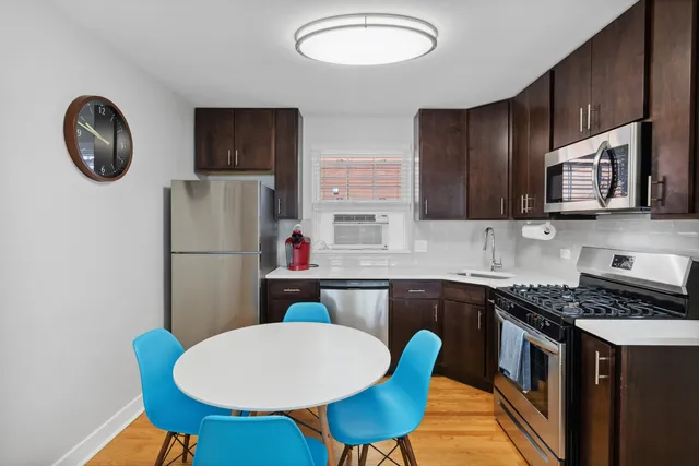 a kitchen with stainless steel appliances granite countertop a refrigerator a stove a sink dishwasher with a dining table and chairs