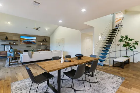 a kitchen with a stove a sink a kitchen island with wooden cabinets and wooden floor