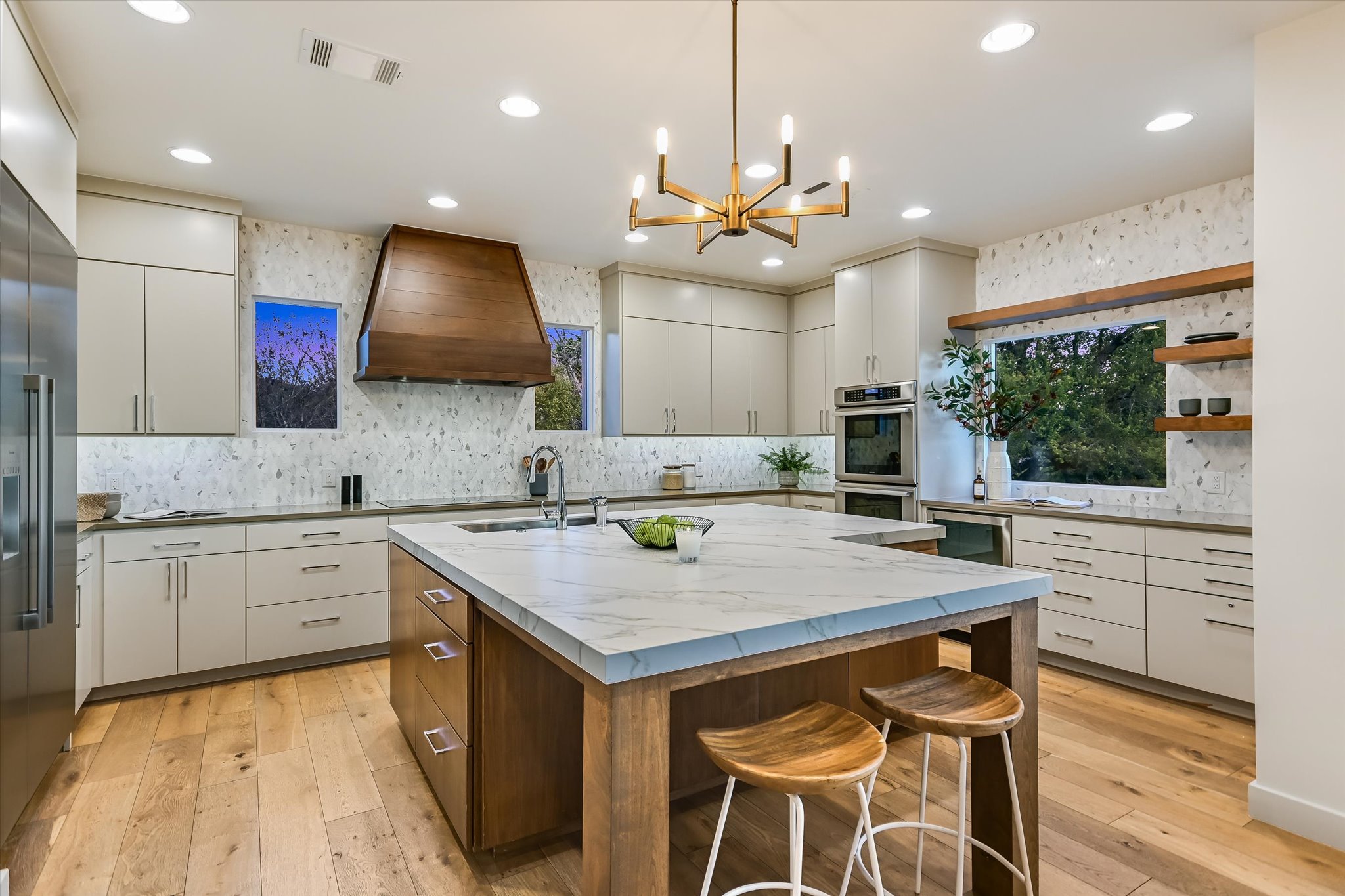 14 Rob Roy Road Austin, TX 78746 - Photo 13 of 40 a kitchen with a stove a sink a kitchen island with wooden cabinets and wooden floor