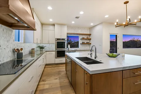 a living room with furniture large window and wooden floor