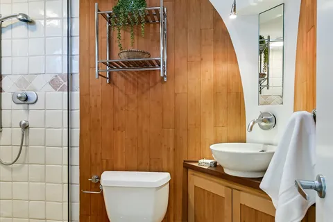 a bedroom with a bed potted plant with the dresser