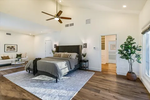 a spacious bathroom with a granite countertop double vanity sink a mirror and a bathtub