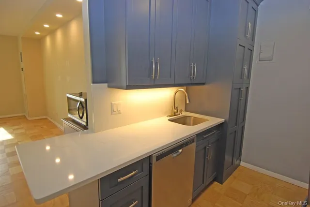 a kitchen with a sink cabinets and wooden floor
