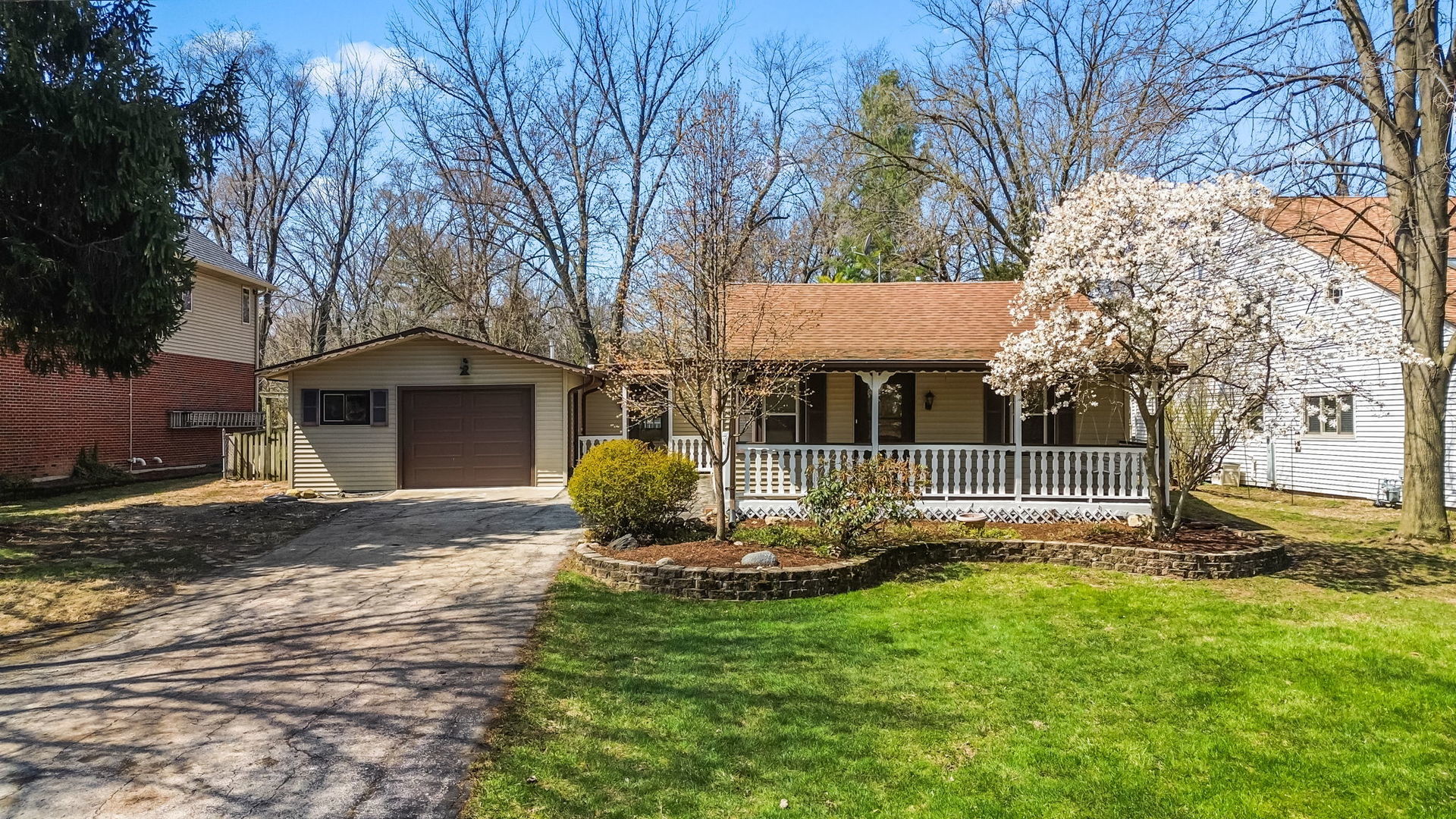 a front view of a house with a garden and tree