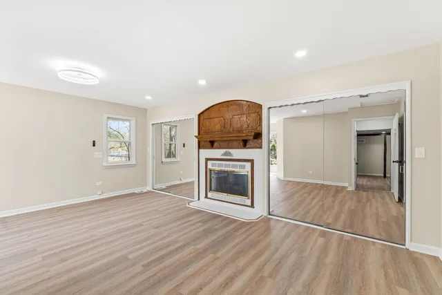 a view of a livingroom with a fireplace wooden floor and cabinet