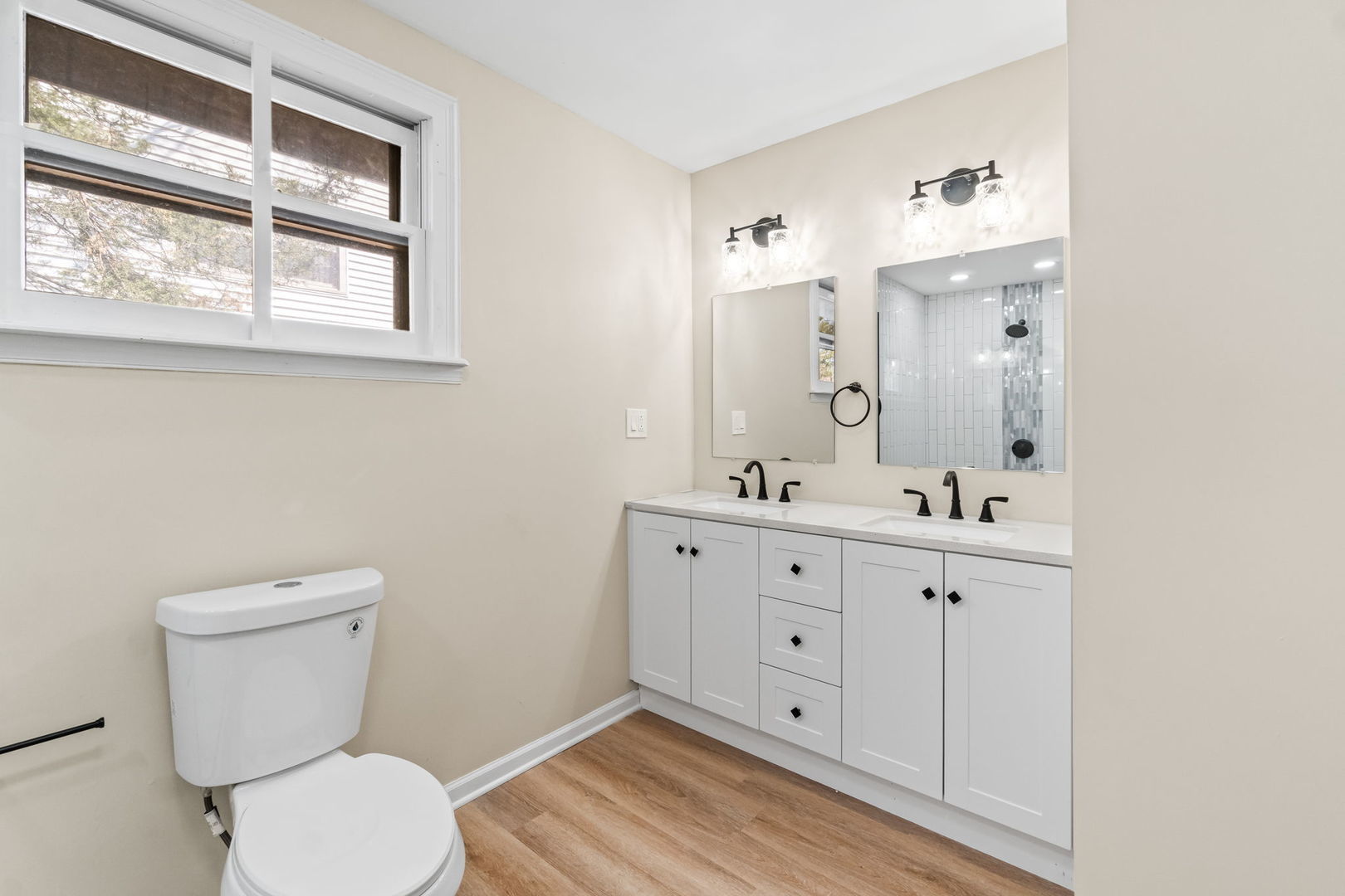 7730 Virginia Court Willowbrook, IL 60527 - Photo 15 of 23 a bathroom with a toilet a sink a mirror and a window