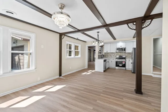 a view of a big room with wooden floor and windows