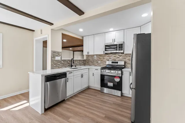 a kitchen with stainless steel appliances granite countertop a stove and a refrigerator