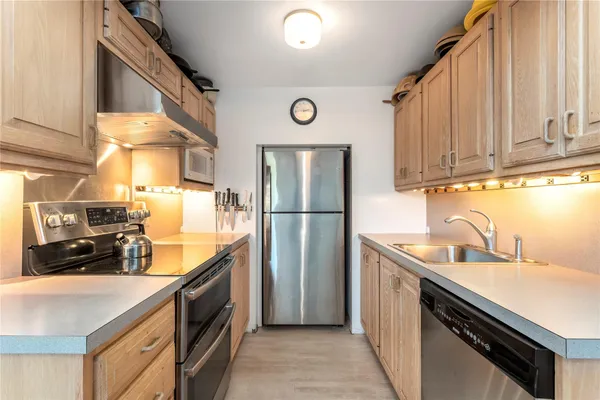 a kitchen with stainless steel appliances granite countertop a sink stove and refrigerator